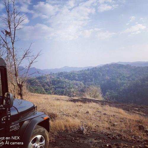 a car parked on a dirt road with a view of a mountain at Beyond Eco Living in Munnar