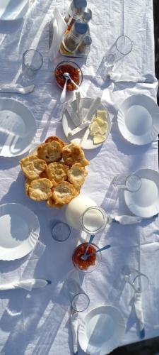 a table with white plates and glasses on it at VILA DISHA in Tirana