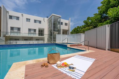 a swimming pool with a wicker basket next to a building at CENTRAL NO 5 LUXURY APARTMENT in Kiama
