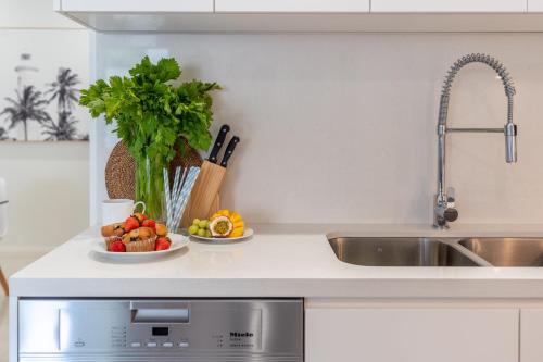 a kitchen counter with a sink and a plate of fruit at CENTRAL NO 5 LUXURY APARTMENT in Kiama