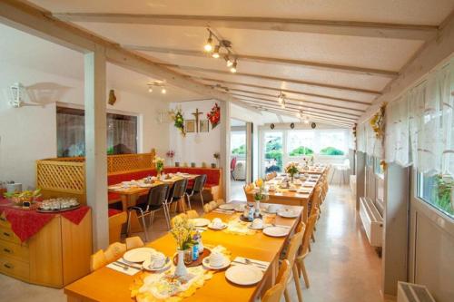 a dining room with long tables and chairs at Hotel-Pension Sandl in Bogen