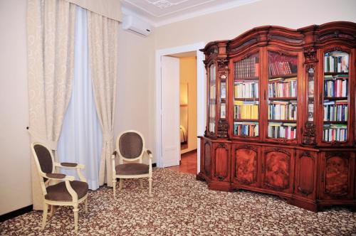 a room with a large wooden bookcase and two chairs at Hotel Alpi Resort in Turin