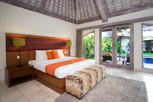 a bedroom with a large bed and a large window at Serene Villas in Seminyak