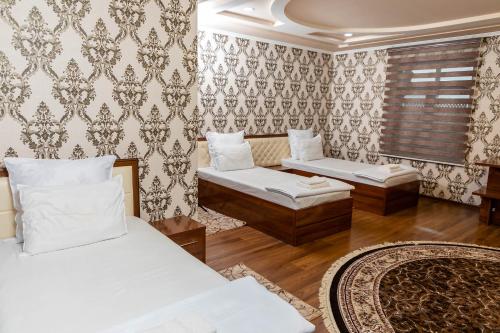 una camera d'albergo con due letti e una finestra di Rohat Hotel a Kokand