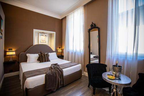 een slaapkamer met een bed, een tafel en een spiegel bij JB Relais in Rome