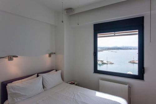 a bedroom with a large window over a bed at Sea & Town Getaway in Chania