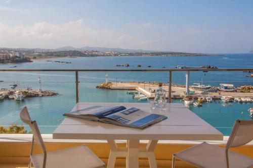 a white table with chairs and a view of the water at Sea & Town Getaway in Chania