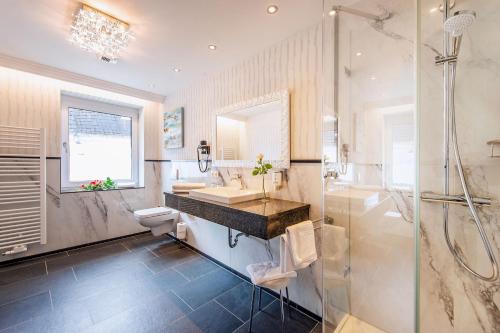a bathroom with a shower and a sink and a toilet at Hotel Residenz am Rosengarten in Bad Kissingen