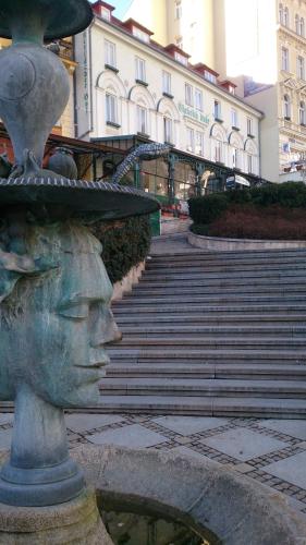 a statue of a woman with a hat in front of stairs at Chebsky dvur - Egerlander Hof in Karlovy Vary