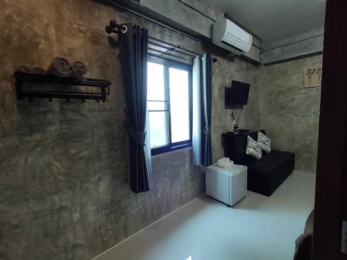 a room with a window and a couch and a table at Amante Baristro Hotel & Cafe' @Pua in Nan