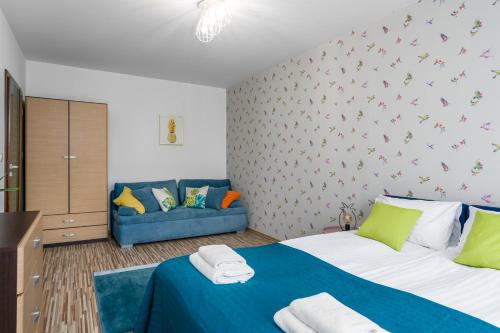 1 dormitorio con 2 camas y sofá azul en Sleepway Apartments - Garbary 95-112a en Poznan