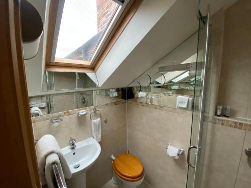 a bathroom with a sink and a toilet and a window at Thompsons Arms in Flaxton