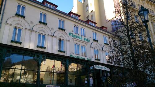 a large white building with a sign on it at Chebsky dvur - Egerlander Hof in Karlovy Vary