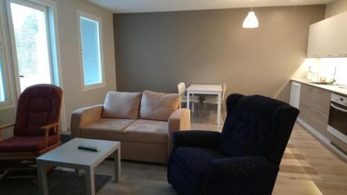 a living room with a couch and chairs and a table at Apartment Pistoolintie in Pyhäjoki