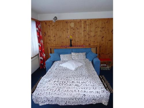 a bedroom with a bed with a blue head board at Curtinfess Rezzonico in Bivio