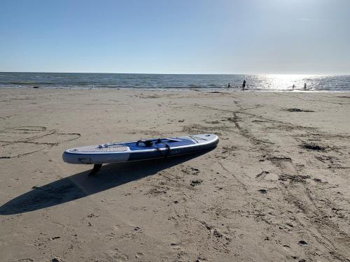 a kayak is sitting on the sand on the beach at Appartement familial plein centre Hardelot Plage in Hardelot-Plage