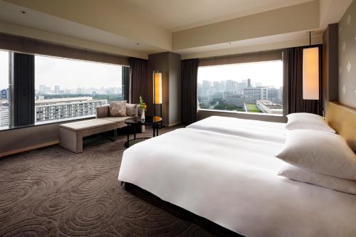 a hotel room with a large bed and a large window at The Capitol Hotel Tokyu in Tokyo