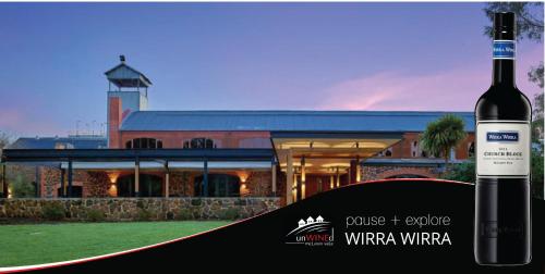 a bottle of wine in front of a building at McLaren Vale Studio Apartments in McLaren Vale
