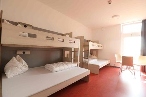 a bedroom with two bunk beds and a desk at Jugendherberge Bad Malente in Malente