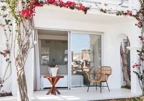a room with a balcony with a table and a bed at Destino Pacha Ibiza - Entrance to Pacha Club Included in Talamanca