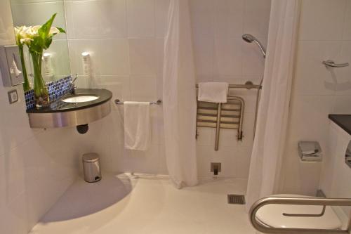ein weißes Bad mit einem Waschbecken und einer Dusche in der Unterkunft Holiday Inn Express Campo de Gibraltar-Barrios, an IHG Hotel in Los Barrios