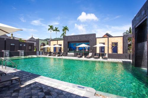 a large swimming pool with chairs and umbrellas at Pavilion Pool Residence Samui - SHA Extra Plus in Lamai