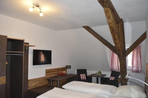 a bedroom with two beds and a table and chairs at Gasthof Pension Zum goldenen Hirschen in Burgbernheim