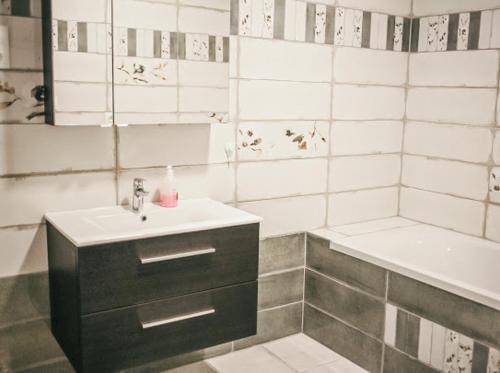 ein weißes Badezimmer mit einem Waschbecken und einer Badewanne in der Unterkunft George Apartman in Sárvár