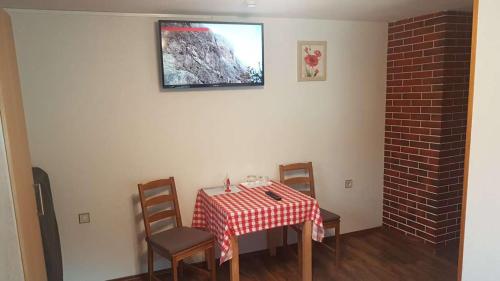 a dining room with a table and chairs and a tv at Pension Haus Rohrmoser in Annaberg im Lammertal