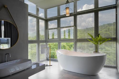 a bathroom with a tub and a large window at Kenting Fu Bao Inn in Hengchun South Gate