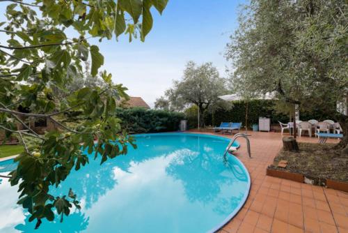 uma grande piscina azul num quintal em villa di charme con piscina e jacuzzi tra Roma e Viterbo em Fabrica di Roma