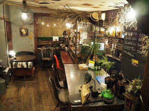 熊本的住宿－民泊カフェ Gootarian，一间酒吧,里面摆放着椅子和桌子