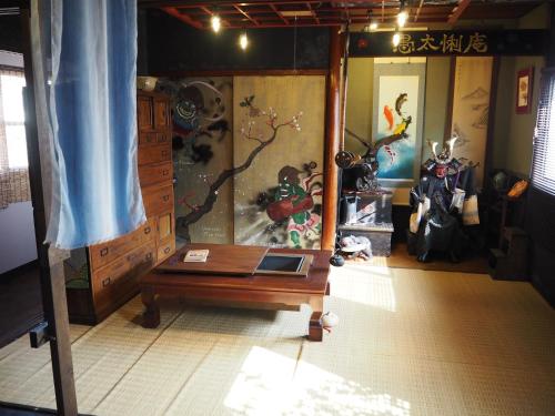 a room with a table and a painting on the wall at 民泊カフェ Gootarian in Kumamoto