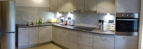 a kitchen with a sink and a stove at Au Frêne Centenaire in Bras