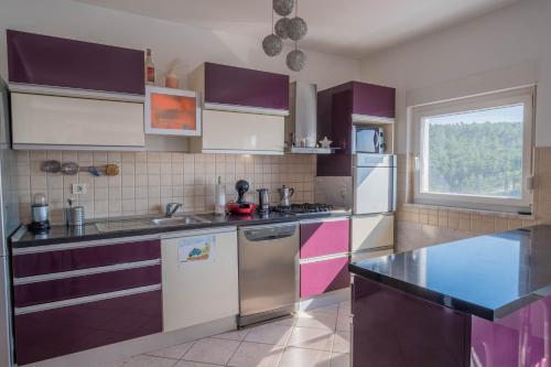 a kitchen with purple and white appliances and a window at Apartman Ahel Jadranovo in Jadranovo