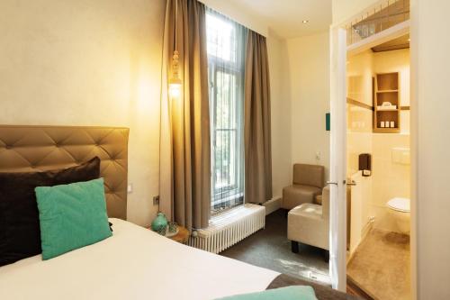 a hotel room with a bed and a window at Hotel Restaurant De Wolfsberg in Groesbeek