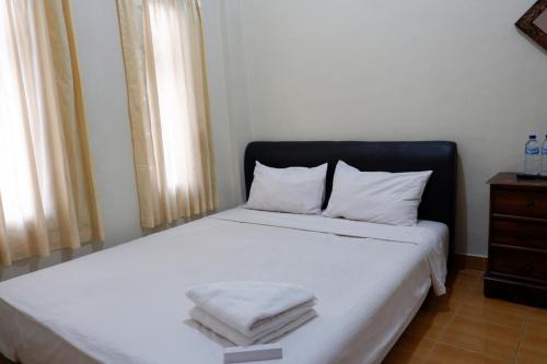 Postel nebo postele na pokoji v ubytování Khresna Guest House Malioboro Mitra RedDoorz