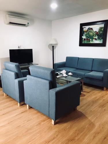 a living room with two blue couches and a table at ALUNA Ben Thanh Hotel in Ho Chi Minh City