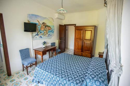a bedroom with a bed and a desk and a television at Nido Degli Dei in Agerola