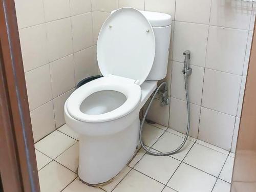 - une salle de bains avec des toilettes blanches dans une cabine dans l'établissement Apartemen Sentra Timur Residence - Cheap Inn Tower Orange, à Jakarta