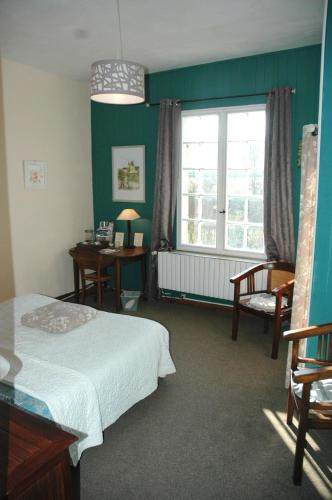 une chambre avec un lit, une fenêtre et un bureau dans l'établissement Domaine de la Queyssie, à Saussignac