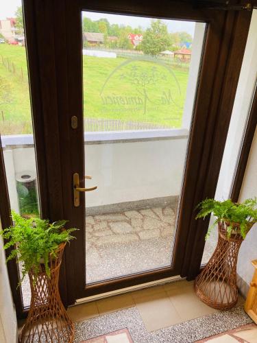 two vases sitting in front of a glass door at Na Kamieńcu in Czarny Dunajec