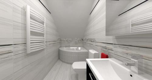 a white bathroom with a sink and a tub at Holiday home Limanowa in Limanowa