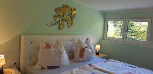 um quarto com uma cama com almofadas e um relógio na parede em Apartment Claudia em Gröbming
