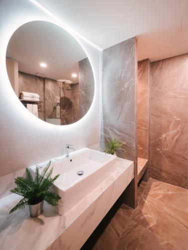 a bathroom with a white sink and a mirror at 56 Hotel in Bangna