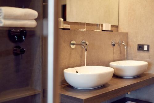 a bathroom with two white sinks on a counter at Hotel Restaurant De Wolfsberg in Groesbeek