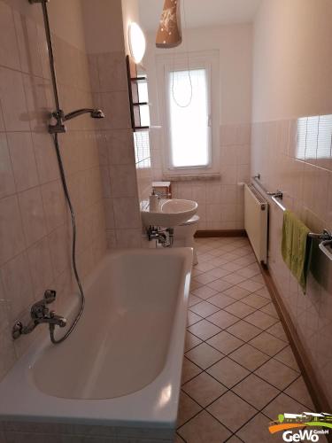 Baño blanco con bañera y lavamanos en Ferienwohnung Karl 54, en Gelenau