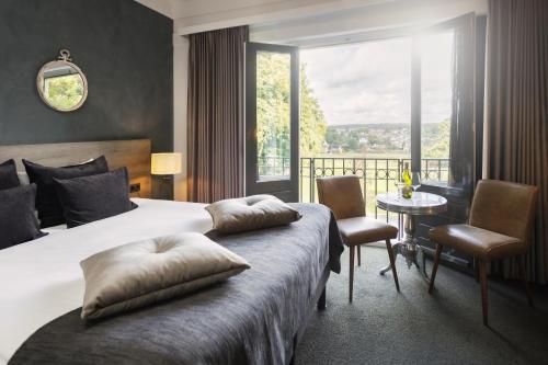 a hotel room with a bed and a large window at Hotel Restaurant De Wolfsberg in Groesbeek