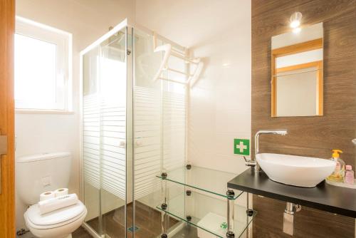 La salle de bains est pourvue d'une cabine de douche en verre et de toilettes. dans l'établissement C14 - Casa da Luz, à Luz