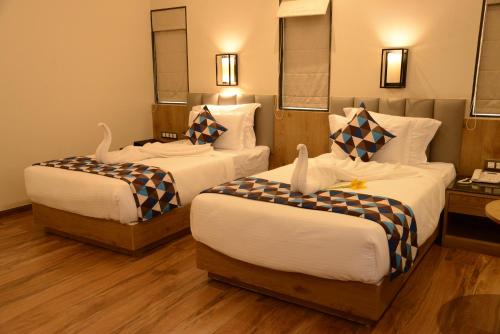 Una cama o camas en una habitación de Lords Inn Jamnagar -Motikhavdi